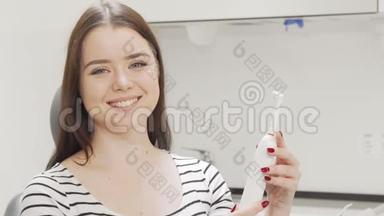 漂亮的女人在检查电动牙刷