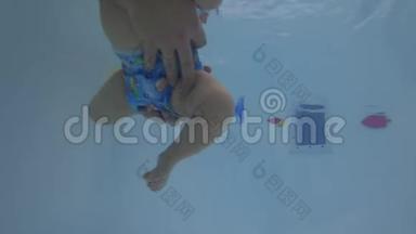 快乐宝宝学习在游泳池游泳.. 宝贝学习游泳。 未编辑的水下录像。