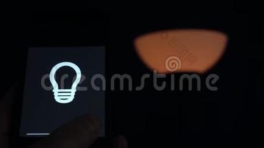 智能家居：男人用手机上的应用程序控制灯光。