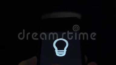 智能家居：男人用手机上的应用程序控制灯光。