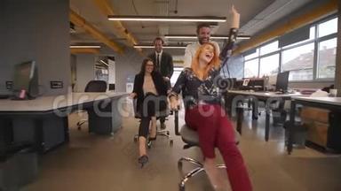 办公室工作人员在办公室里玩得开心，在办公室椅子上滚动