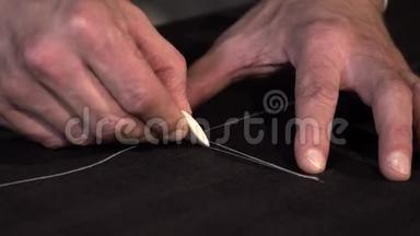 一个裁缝在把布料切成小块之前在布料上做最后的记号