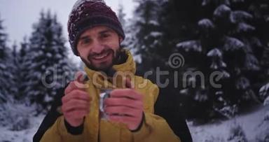 冬天的时候，在<strong>森林</strong>中的一个漂亮的<strong>游客</strong>在喝热饮料的时候，直视着摄像机