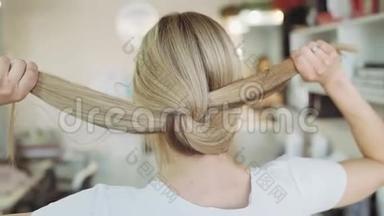 美丽的淡色女人在美容院从背后露出头发