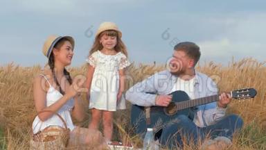 欢乐的家庭郊游，爸爸演奏弦乐器，妈妈拍手，小女儿跳舞