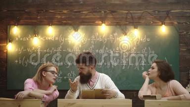 老师和两个女学生讨论绿板的背景，在上面写公式。 学习过程