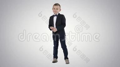 穿着正式服装的小男孩在渐变背景上说话和微笑。