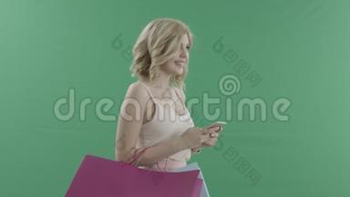 有魅力的女人带着手机和包包，在绿色的屏幕上迎接别人