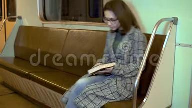 一位年轻女子正在<strong>地铁</strong>火车<strong>上</strong>看书。 旧<strong>地铁</strong>车