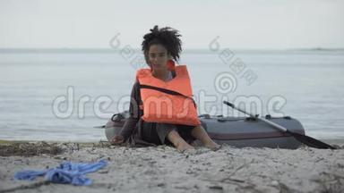 少女穿着救生衣坐在船边，<strong>难民</strong>在船上幸存下来