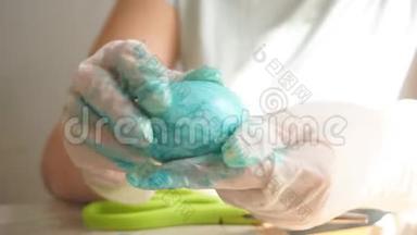 紧紧抓住一个戴着手套`女人的手在画一个复活节彩蛋