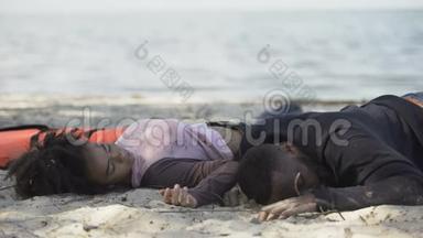 非裔美国人夫妇躺在岸边昏迷不醒，难民在海难中幸存下来