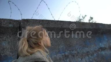 小<strong>难民</strong>女孩看着铁丝网，梦想着新的家园，移民