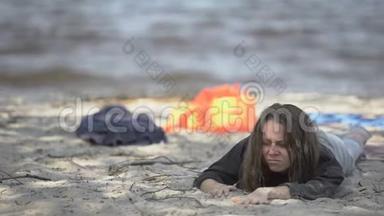 不幸的女人躺在岸上，感觉不舒服，遇难的<strong>难民</strong>幸存者