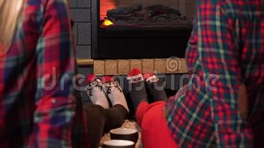 两个女孩坐在壁炉旁，穿着袜子，像一只鹿。 舒适的壁炉旁有几英尺的袜子