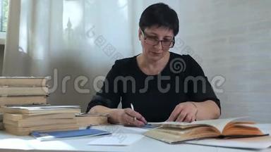 一个戴眼镜的女人，手里拿着铅笔，在纸上做笔记，思考和思考，写诗和诗歌。 创造力
