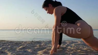太阳升起时，穿黑色紧身衣的运动黑发女人在<strong>海边</strong>做<strong>瑜伽</strong>。 健身，运动，<strong>瑜伽</strong>和健康的生活方式概念。 4k