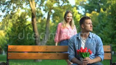 女孩闭上男友的眼睛在公园等着她，带着一束鲜花，惊喜