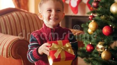 快乐微笑的小男孩在盒子里拿着圣诞<strong>礼物</strong>的视频，并在镜头中展示他的<strong>礼物</strong>。 接<strong>收</strong>儿童