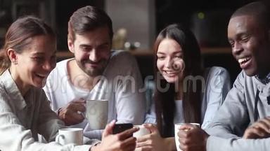 不同的朋友聚集在咖啡馆看智能手机上的有趣视频