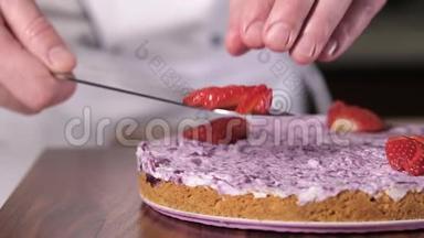 厨师<strong>拿起</strong>切好的草莓，用刀子把他们准备好的奶酪蛋糕。
