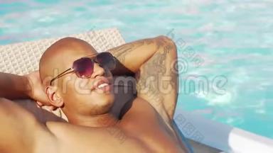 一个快乐的非洲男人在泳<strong>池边</strong>放松的弯下的滑射