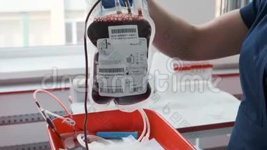 一名护士拿着一个塑料袋，里面放着献血者的血。 血液样本。 输血和捐献概念