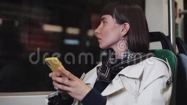 坐在公共<strong>交通工具</strong>里，望着窗外的年轻沮丧的女人。她手里拿着智能手机