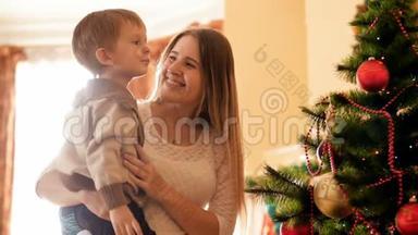 快乐的母亲和她的小儿子站着<strong>看房</strong>子里腐烂的圣诞树的4K镜头。 家庭