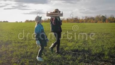 年轻的母亲和她的女儿在农场收割蔬菜。 收割期间农民家庭小组剪影