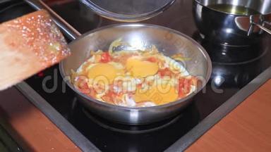 厨师做了一个煎蛋卷，把鸡蛋放在一个平底锅里，配上切碎的西红柿和洋葱，然后用蔬菜做煎蛋卷。