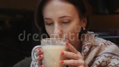这段视频是关于年轻迷人的女人在餐馆喝咖啡茶的。 她的肩膀上覆盖着温暖的<strong>针织衫</strong>