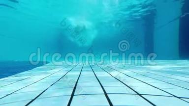 当<strong>一个人</strong>在游泳池里游泳时，从水下射击。 <strong>一个人</strong>游离水面上的摄像机