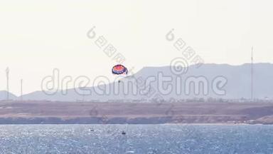 穿越海面的降落伞将游客拖走。 寄生在红海里.. 假期概念