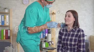 一位医生用棉签从一位年轻女子口中取出唾液`