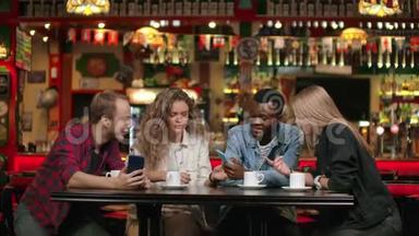一群多民族的学生，三个欧洲人和一个非裔美国人，看着手机屏幕，笑着讨论
