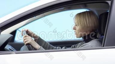身着便装的金发女子<strong>驾</strong>驶着绿色屏幕背景的汽车。 4.她正坐在车上喝着<strong>酒</strong>