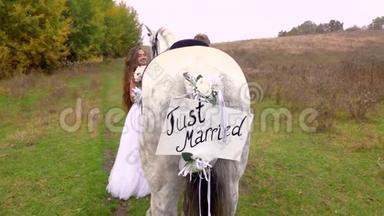 刚<strong>结婚</strong>的新娘和新郎站在马旁，手里拿着刚<strong>结婚</strong>的铭文。