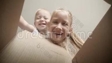 两个孩子看着一个盒子。 快乐儿童<strong>开幕</strong>礼物。