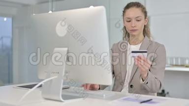 年轻女商人在桌面上庆祝网上支付成功