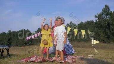 孩子们的快乐，快乐孩子们的朋友们在暑假里在wigwam的背景下快乐地跳跃和唱歌。