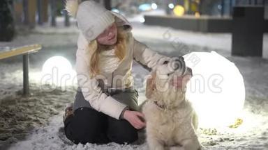 家庭中宠物的<strong>幸福生活</strong>.. 冬天，漂亮的女孩在户外抚摸她的狗。