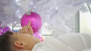 歪歪扭扭的<strong>视频</strong>，小孩子躺在圣诞树下，玩着<strong>粉红</strong>色的球。