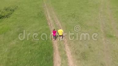 体育少年和她父亲在草地上奔跑，空中镜头