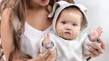 聚焦可爱宝宝穿着白色衣服拍手看镜头特写的画像