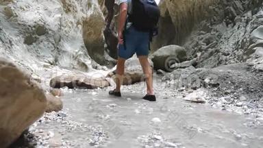 一群年轻的徒步旅行者穿过狭窄的峡谷。 游客们漫步在崎岖不平的地形中，<strong>四处</strong>观赏