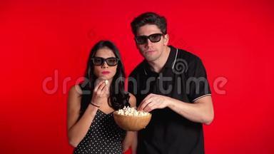 年轻夫妇在<strong>电影院</strong>3d眼镜观看迷人的恐怖电影和吃<strong>爆米花</strong>的红色工作室背景。