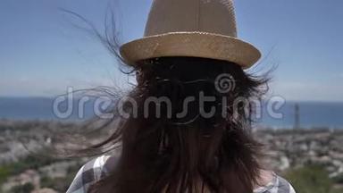 戴帽子的女人俯视城市和大海，仰视风景，旅行理念