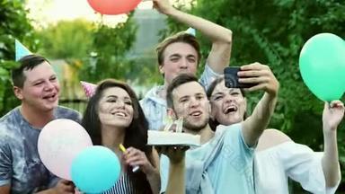 快乐男人在庆祝生日的时候在手机上自拍，朋友祝贺，在手机上拍照