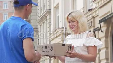 可爱的女人从送货员那里收到纸板箱包裹